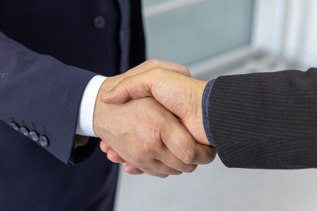 Close-up of two business professionals shaking hands, symbolizing partnership and collaboration.
